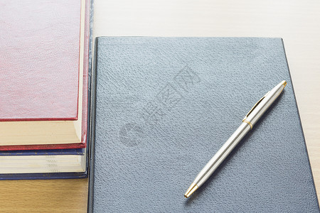 个人杂志素材笔放在笔记本上学校合同笔记记录桌子皮革软垫床单杂志木头背景