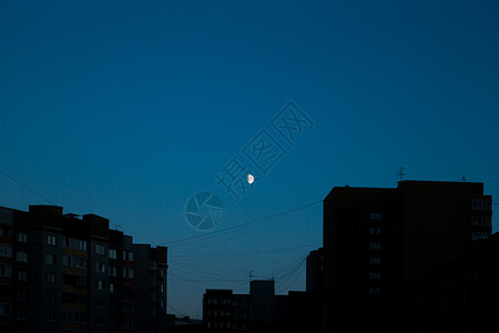 上弦月月亮在城市上升起背景