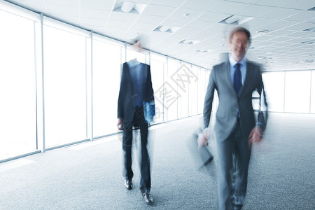 步行商务人士的模糊画像办公室公文包蓝色商业套装工人运动男人背景图片