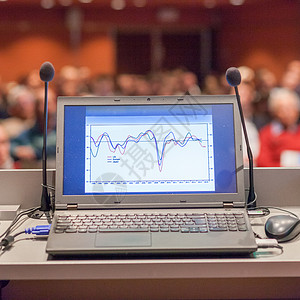 商务活动讲台上的计算机和麦克风中心图表国会大厅平台商业工具推介会电脑大学背景图片