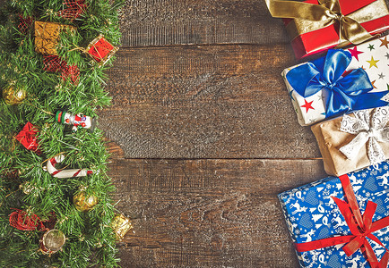 圣诞园地 有玩具和礼物 在黑暗的木头背角金子作品雪人松树风格卡片盒子花环庆典装饰背景