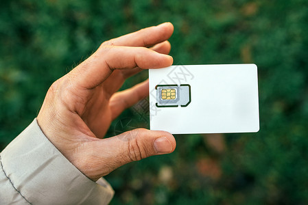 手机模块素材持有移动电话的男性手SIM卡电子系统技术网络细胞芯片手机数字身份卫星背景
