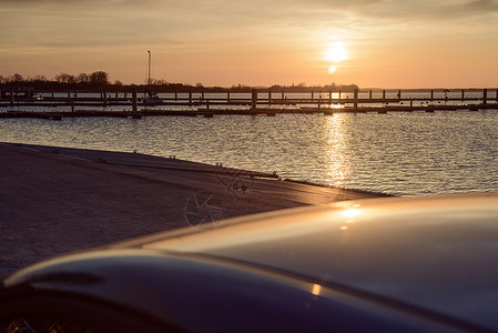 橙色日落过游艇港旅行房子码头运动港口蓝色太阳航海海洋动物背景图片