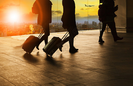 在机场候机楼内行走的旅客和旅行行李套装交通闲暇运输女性人员城市商业假期全体背景图片