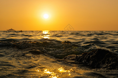 海浪在日落时紧闭 红色和橙色的太阳反射到水面上 自然抽象地模糊背景 泰国普吉岛天空波浪旅行假期冲浪阳光背光地平线海景反思背景