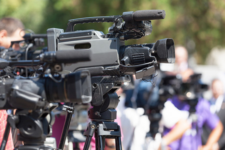 记者招待会 电视摄影机聚焦于模糊的屏障背景图片