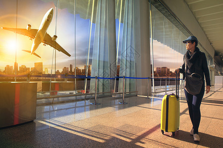 旅行妇女和行李在机场候机和飞机上行走飞机场窗户女性乘客假期商业全体航班运输空气背景图片