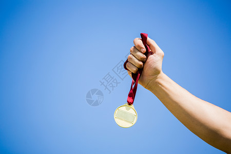 胜利后手握金牌的运动员竞技运动成就丝带能力体育场天空男性奖牌男人背景