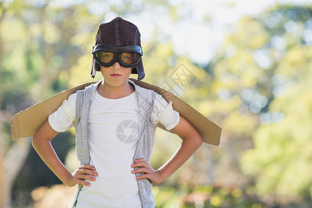 假扮航空飞行员的男孩绿地喜悦想像力娱乐翅膀公园纸板服装晴天护目镜背景图片