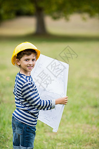 戴硬帽子的男孩有计划想像力草原男性公园男生晴天蓝图服装快乐工程师背景图片
