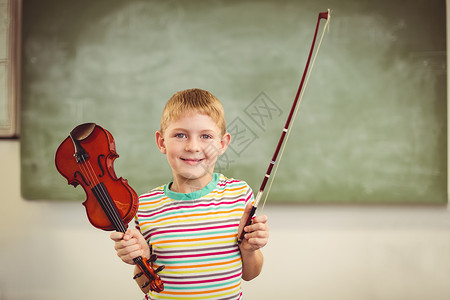 男生拉小提琴微笑的男孩在课堂上拉小提琴的肖像背景