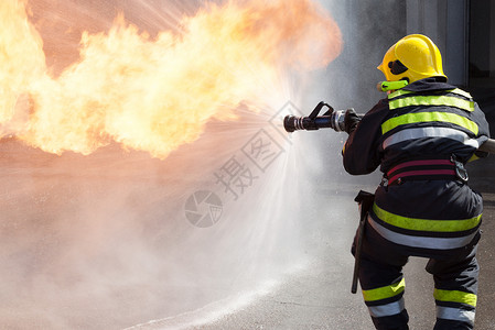 消防员在行动服务情况训练喷涂丙烷消防队员锻炼气体危险头盔背景图片