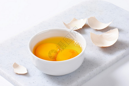 裂开的鸡蛋碗中的蛋白蛋和蛋黄蛋盘子棕色鸡蛋蛋白白色蛋壳背景