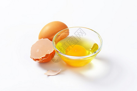 在玻璃碗中的蛋白和蛋黄棕色鸡蛋蛋壳盘子高清图片