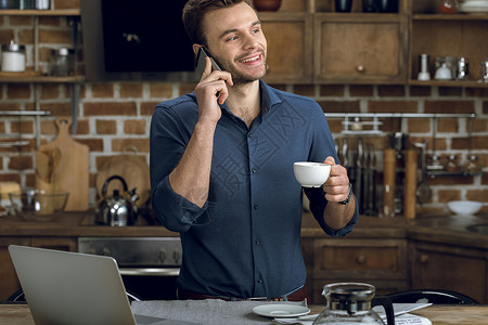 快乐的年轻人在智能手机上聊天 并举着咖啡杯商业咖啡办公笔记本早餐饮料工作者微笑职业商务男人高清图片素材