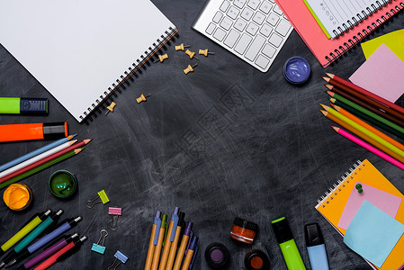 黑板背景的学校文具或办公用品学期木板图书笔记本班级桌子白色学习粉笔大学背景图片