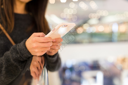 社会地位女性使用移动电话的情况短信女孩店铺背景购物中心金子桌子手机互联网木头背景