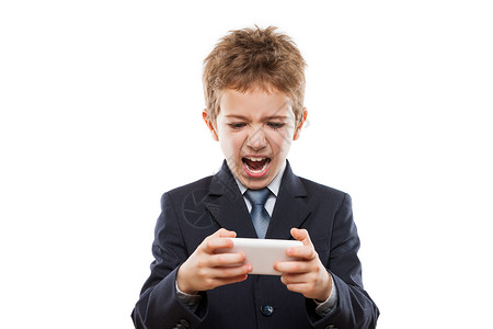 玩游戏或上网使用智能手机打情网时 在商业西装中微笑的男孩背景
