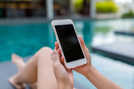 妇女在游泳池中使用手机的情况高清图片