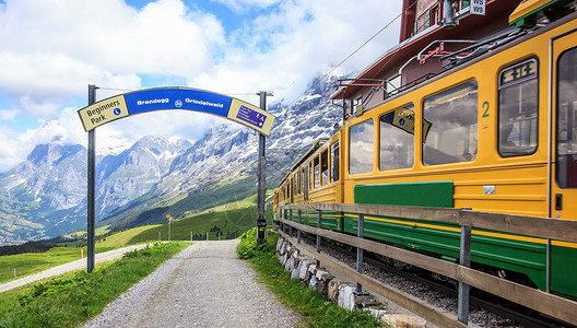 素坤逸车站从车站开往瑞士格林德瓦尔德的瑞士铁路列车开始步行小道的起点标志 沿着绿色新鲜草甸的步道 以雪山为背景背景