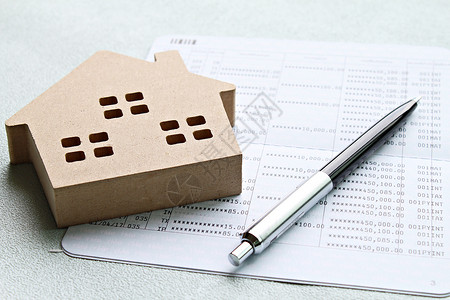 财产租赁合同范本办公桌桌上的木屋模型和财务报表或储蓄账户账簿表背景