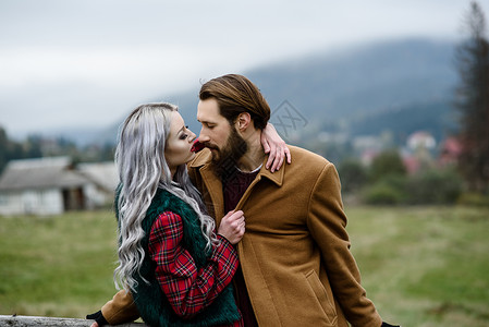 任督二脉喀尔巴阡山上的情侣外套拥抱成人前戏夫妻女士笼子栅栏热情红裙子背景