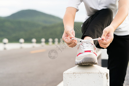 女人在跑步前系紧鞋带运动慢跑者女性运动装鞋类训练赛跑者领带公园女孩图片