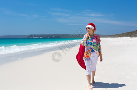 圣诞节在沙滩上 夏日阳光下 女性与圣塔一起散步高清图片