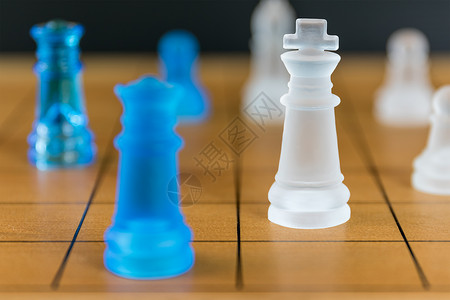 木材棋盘上的象棋玻璃战略桌子领导国王木板骑士智力防御打败白色背景图片