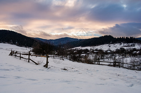 冬天令人欣赏的沿雪路一带的木栅栏背景