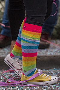 颜色各异的袜子嘉年华参与者的腿背景
