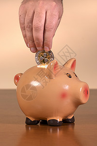 中心化男子在小猪禁令中插入波纹硬币男人现金经济货币男性桌子存钱罐金融电子商务银行业背景