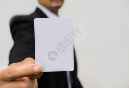 vip卡模板持白底白卡的商务人士之手 他拿着白底黑底白卡问候语广告标识手臂人士套装名片男人展示会议背景