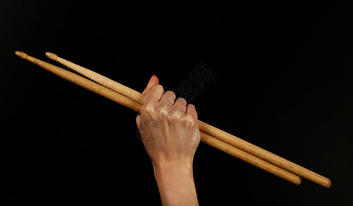 紧紧女人的手 用铁棍敲在黑色上音乐摇杆鼓手电视指甲展示拳头红色音乐家音乐会背景图片