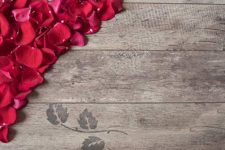 花瓣形状边框木制背景上的红色玫瑰花瓣 在一张木桌上的玫瑰花瓣边框 顶视图 复制空间 花卉框架 风格营销摄影 婚礼 礼品卡 情人节或母亲节背景背景