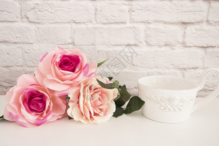 花瓶粉色玫瑰白桌上的一束玫瑰 前天使的一大杯咖啡 浪漫的花卉框架背景 花卉风格的墙模型 玫瑰花模型 情人节母亲节卡 礼品卡背景