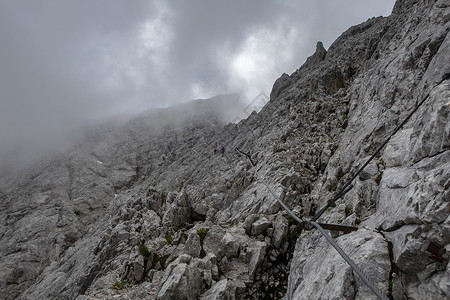 赫伦塔尔在巴伐利亚的Zugspitze通过绳索头盔登山顶峰马具登山者旅游冒险远足运动背景