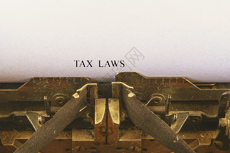 在老式打字机上的特写 前面的重点是制作税法文本的字母 具有复古办公工具的商业概念形象背景