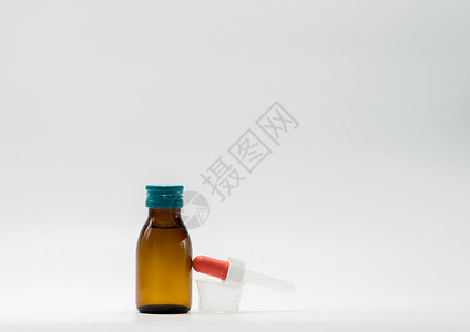 含有白标签和塑料量度杯 白底茶匙的安柏瓶装药糖浆高清图片