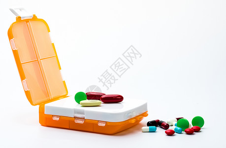 国外素材管理有五颜六色的胶囊药片的橙色药盒在白色背景与拷贝空间隔绝了 在工作或出国旅行概念之前准备药物处方反抗橙子治疗塑料价钱盒子预算抗菌剂背景