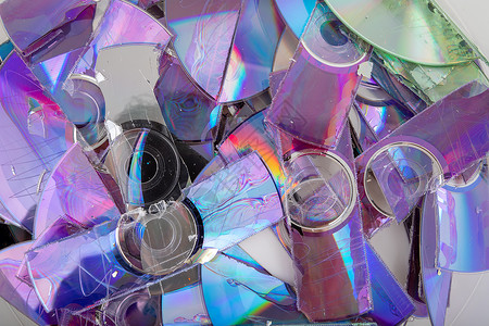 信息碎片化切碎的 CD 和 DVD 数据光盘碰撞电脑备份破坏休息贮存塑料磁盘腐败条纹背景