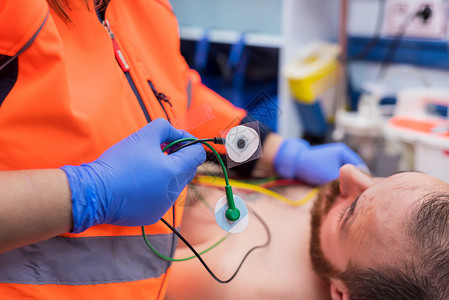 紧急医生手 在救护车的病人胸腔上加电极男性监视器情况诊所脉冲护士健康保健卫生有氧运动背景