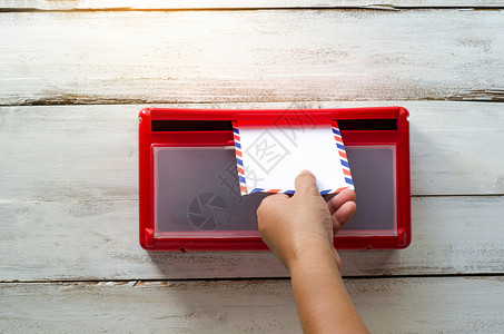 红色信箱双手在信箱里拿起信封邮件女士邮政盒子女孩卡片阳光黄色文档皮肤背景