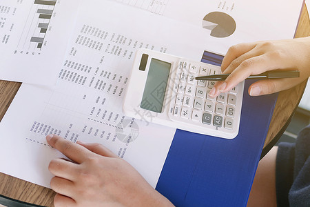 商业女商务人士分析投资图表和迫切的计算数字帐户贷款蓝色检查会计学分男人女士计算器办公室背景