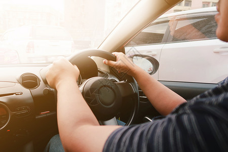 双手驾着方向盘驾驶的男子有选择地关注方向盘运输执照技术男人旅行成人安全控制男性车辆背景