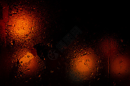 雨槽夜晚五颜六色的大城市灯光透过汽车挡风玻璃 光线散焦和模糊 专注于挡风玻璃 曝光不足的照片背景下雨城市旅行液体反射雨滴天气窗户驾驶背景