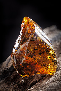 天然的琥珀石 一块石头木头上的肮脏而透明的黄色黄宝石宏观抛光地质学太阳石晴天矿物宝石反射裂缝材料背景