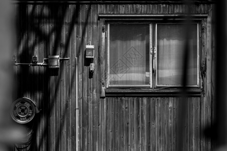 一个小木房子的门面建筑白色阴影木头框架黑色小屋窗户背景图片