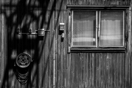 一个小木房子的门面白色窗户建筑框架木头小屋阴影黑色背景图片