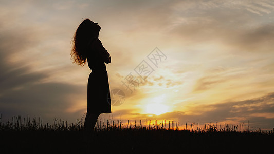 新时达日落时站在干草地上的年轻女子的休眠女孩女性太阳信仰头发头脑宽慰自由喜悦成人背景